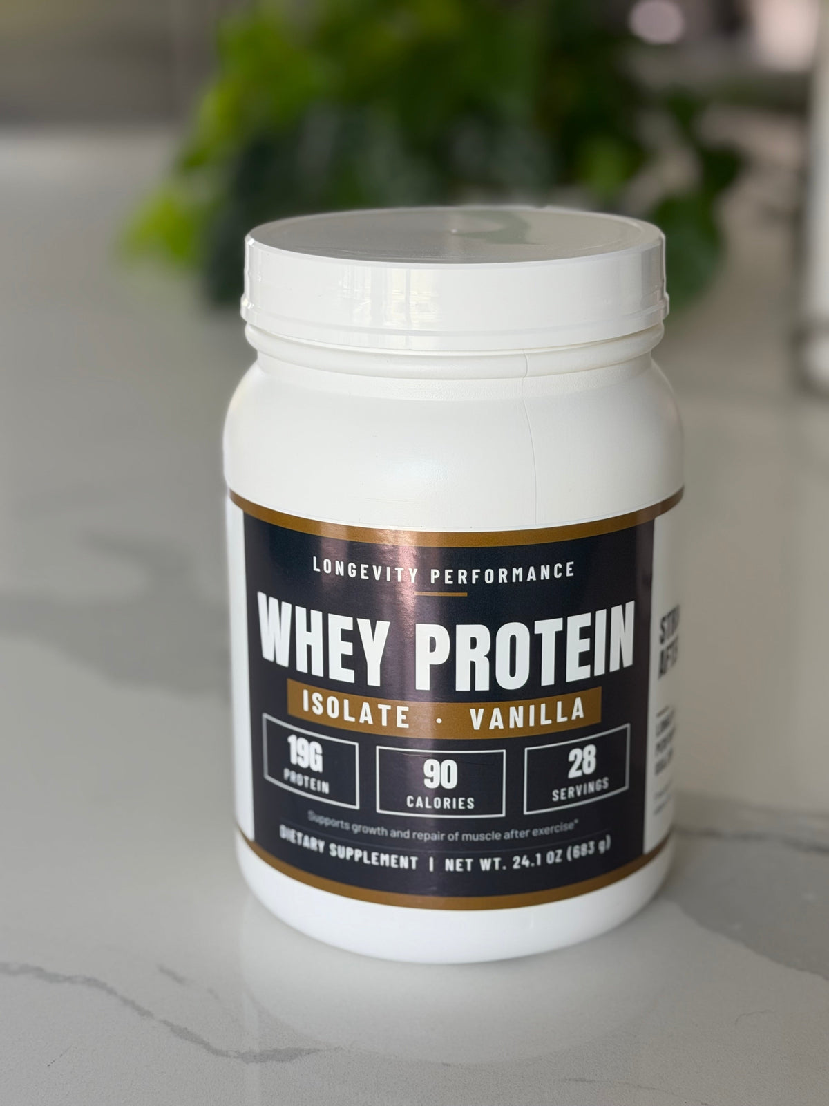 Longevity Performance Whey Protein Isolate Vanilla tub on a kitchen counter